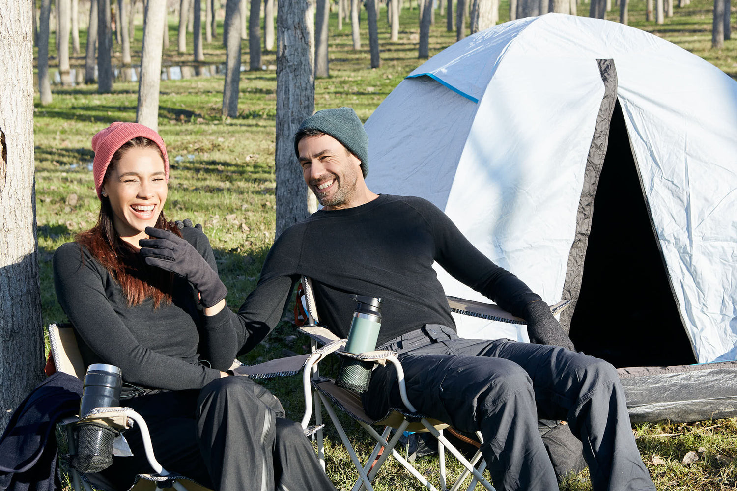 A photo of a woman and a man relaxing in camp chairs.