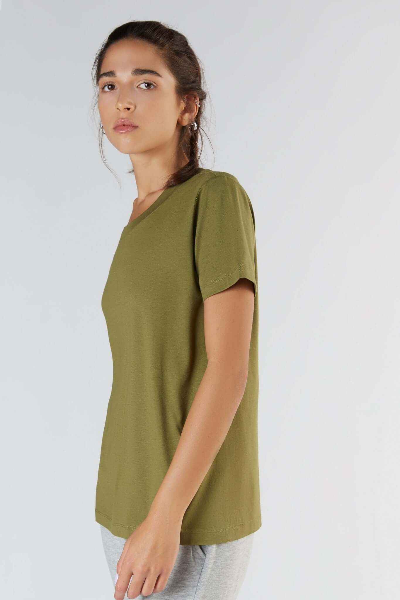 A woman posing with a Olive color clothing.