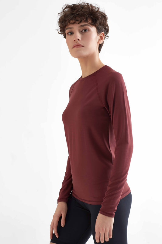 A woman posing with a Burgundy color clothing.