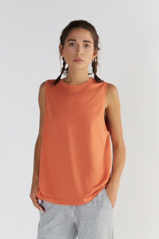 A woman posing with a Soft Orange color clothing.