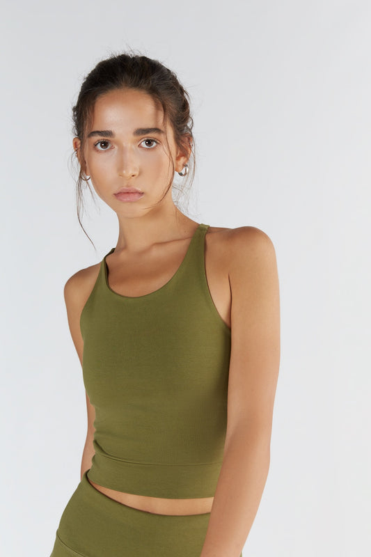 A woman posing with a Olive color clothing.