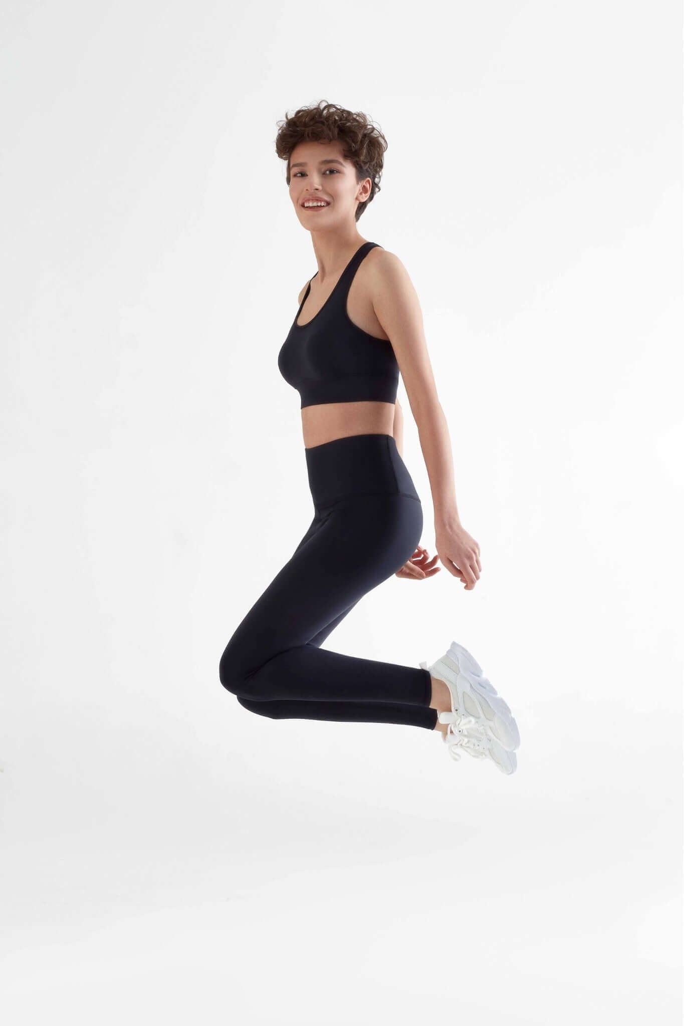 A woman posing with a Black color clothing.