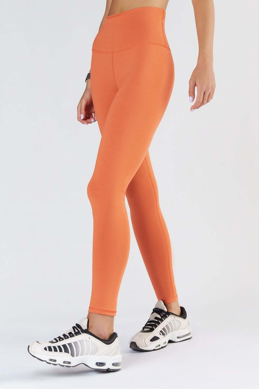 A woman posing with a Soft Orange color clothing.