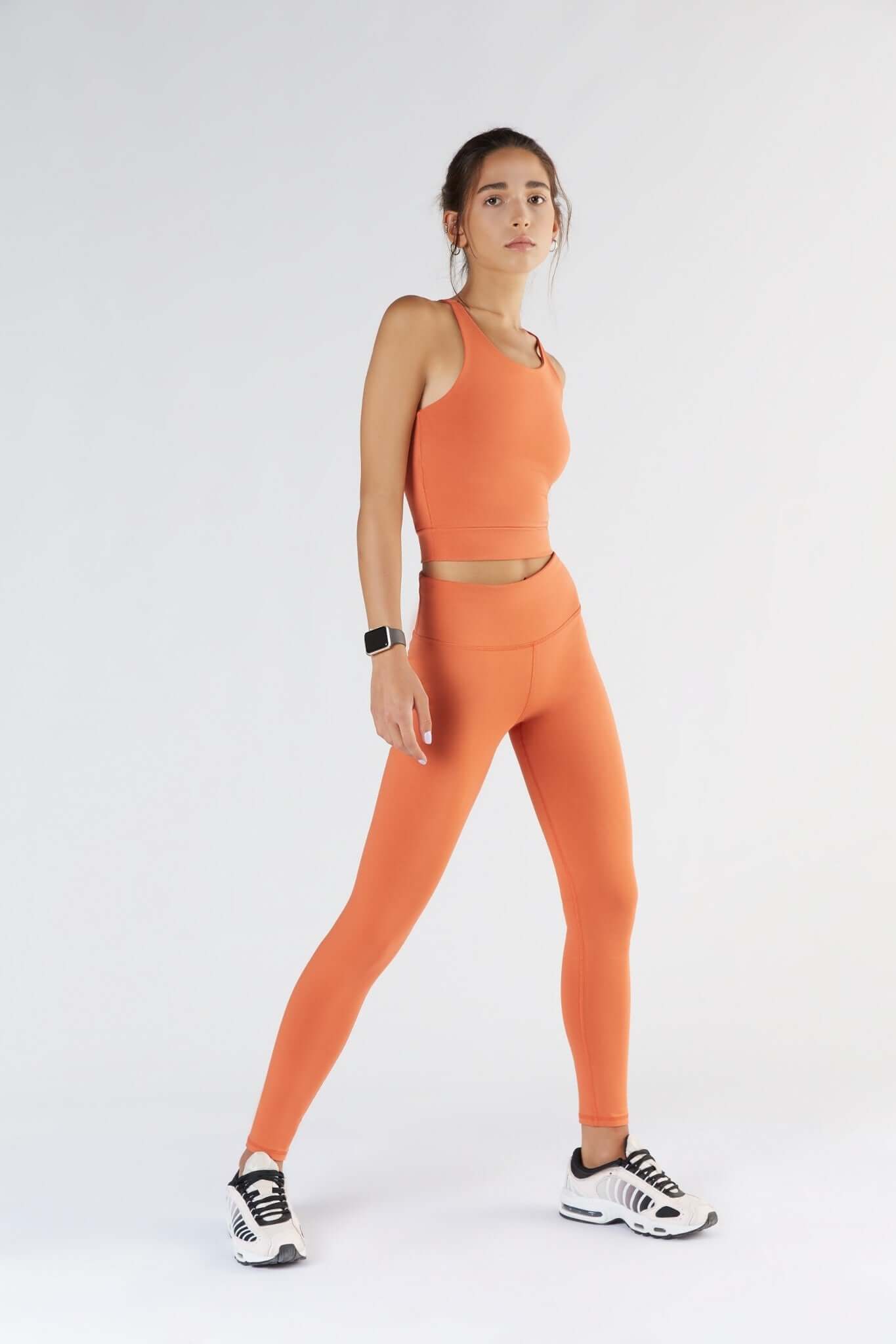 A woman posing with a Soft Orange color clothing.