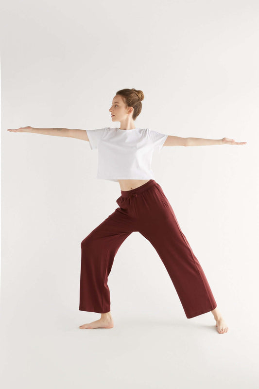 A woman posing with a Burgundy color clothing.