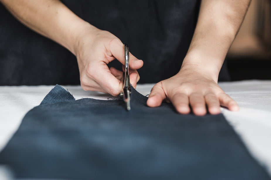 A women cutting a fabric.
